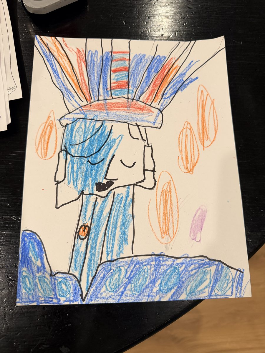 A crayon drawing photographed at an angle on a dark kitchen table